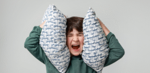 Dziecko zasłania uszy poduszką - zmysły autyzm